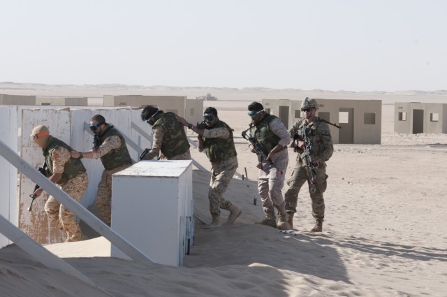 Soldiers from Kuwait's 55th Battalion move to clear a mock village