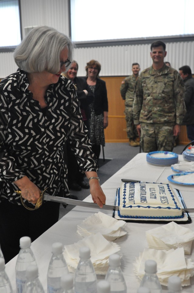 Cheryle Hess cuts a cake during retirement ceremony