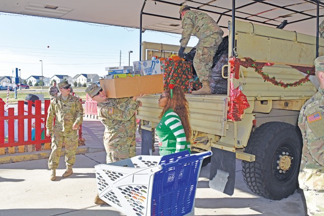 Soldiers of the 1st Armored Brigade Combat Team, 1st Infantry Division at Fort Riley deliver holiday toys.