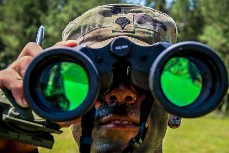 A human recourse specialist from 11th Armored Cavalry Regiment, looks through his binoculars as part of an orienteering event during second day of the 2017 Forces Command Best Warrior Competition at Fort Bragg, N.C., Aug. 21.