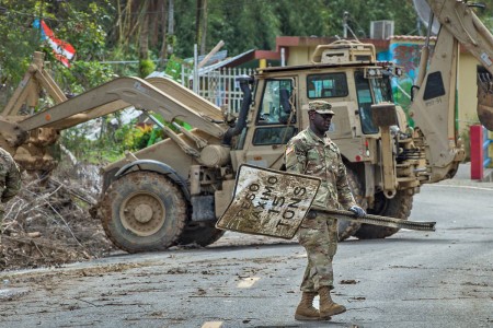 A South Carolina National Guard Soldier with Task Force Palmetto, helps clear a road in the vicinity of Cayey, Puerto Rico. The Soldiers are working in conjunction with the 190th Engineer Battalion of the Puerto Rico National Guard to clear mud...