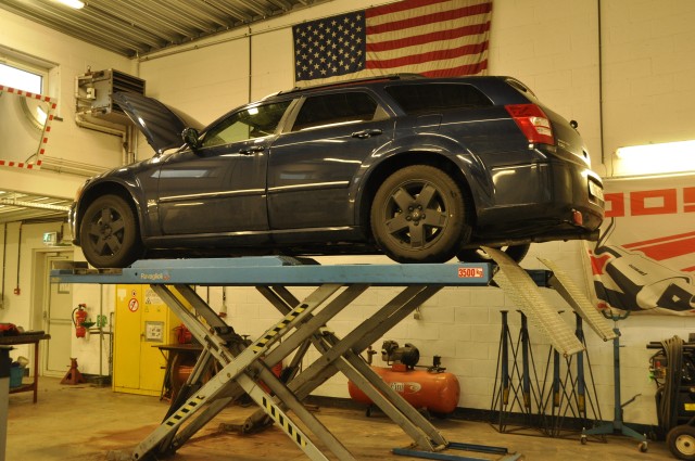 A car is elevated on a work bay