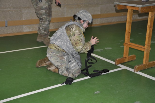 Spc. Sandra Cruz assembles a gun before stress shoot during Best Warrior Competition