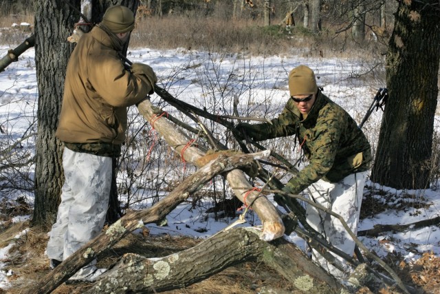 Cold-Weather Operations Course Class 18-04 students build improvised shelters during training at Fort McCoy