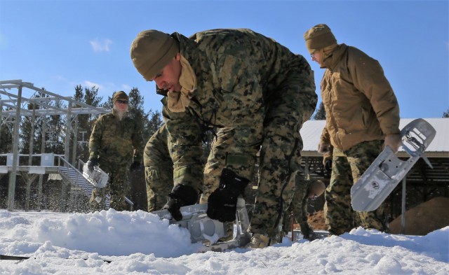 Cold-Weather Operations Course Class 18-04 students build Arctic tents during training at Fort McCoy