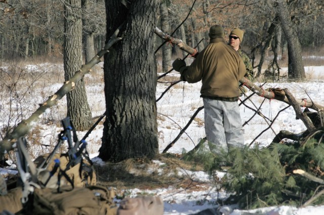 Cold-Weather Operations Course Class 18-04 students build improvised shelters during training at Fort McCoy