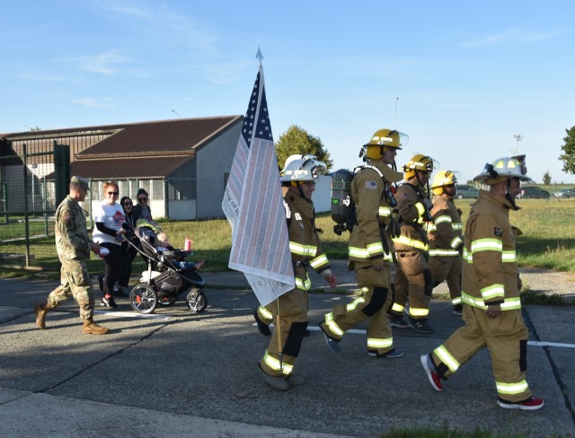 Firefighters carry an American flag in Patriot 5K Run/March