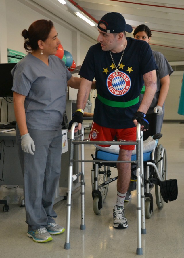 Iveri Buadze walks with Physical Therapy Assistant Maria Duluc