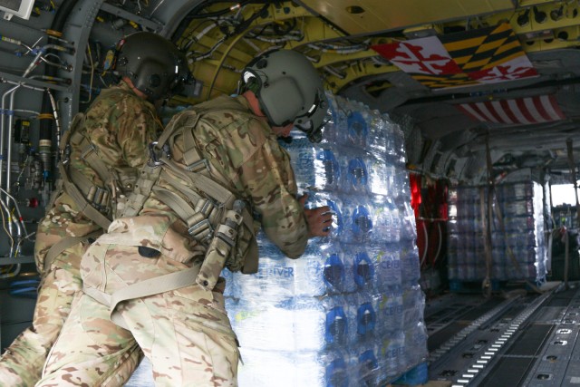 Maryland Army National Guard Soldiers load pallets of water into a CH-47F helicopter for hurricane response