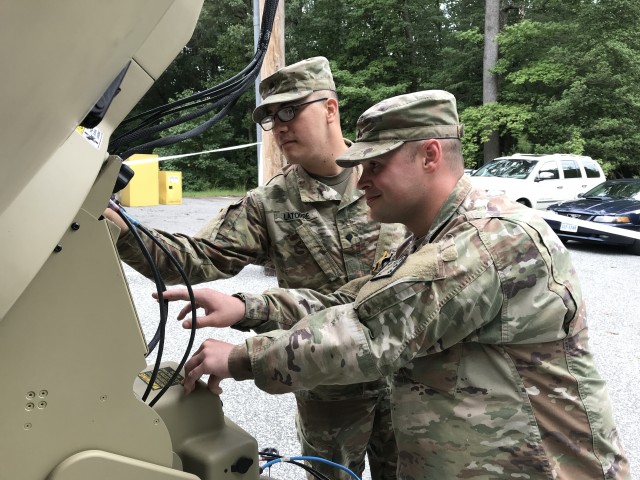 Soldiers check satellite dish during exercise