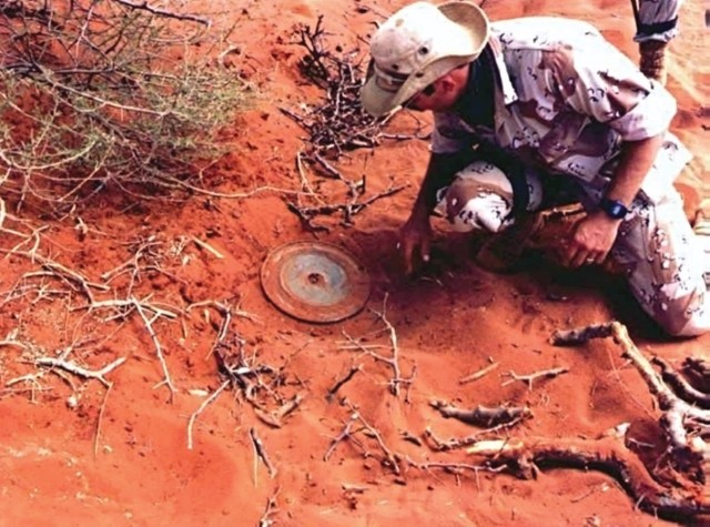U.S. Special Forces Soldier uncovers a Russian TM46 mine during demining operations as part of U.S. humanitarian aid