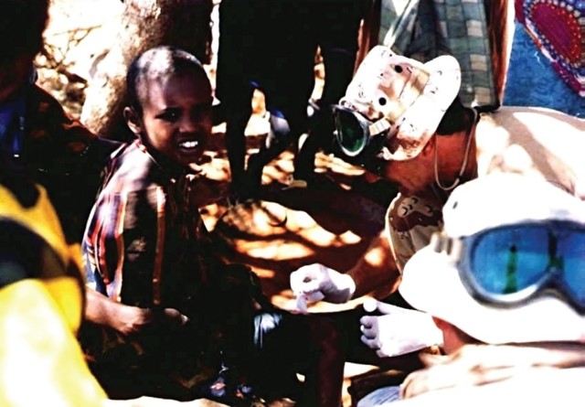 Special Forces Medical Sergeant assigned to the 5th, Special Forces Group, treats a child as part of U.S. humanitarian aid relief efforts in Somalia in the early 1980s