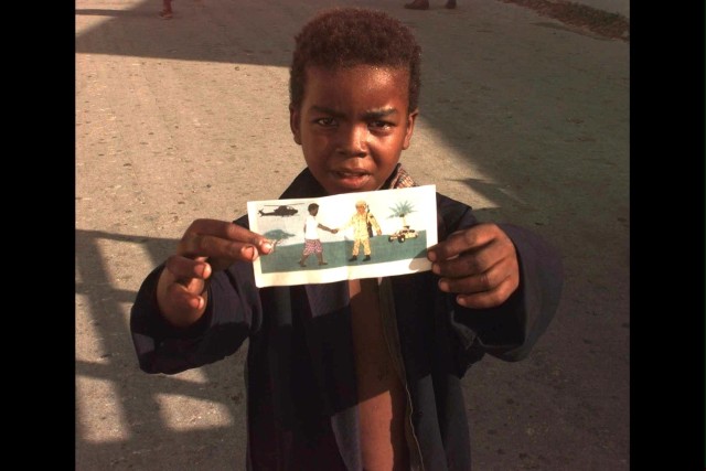 Somali boy holds PSYOP leaflet during U.S. humanitarian aid relief effort operations