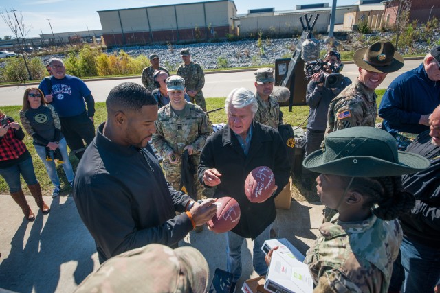 Strahan and Johnson sign footballs