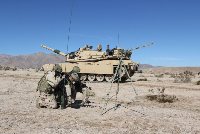 Cyber Soldiers at NTC by an M1