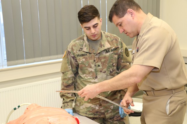 Navy surgeon teaches Army combat medic to insert a chest tube