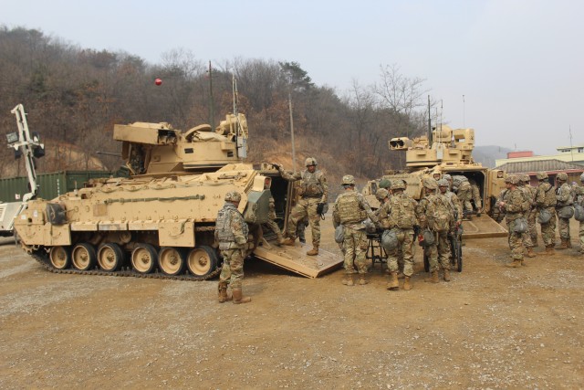 Soldiers unloading patients from M2A3 Bradley