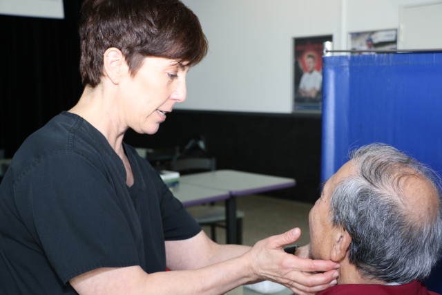 Tracey Fischer, LRMC speech-language pathologists, examines patient for head and neck cancer symptoms