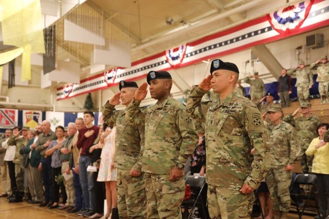 Command Sgt. Maj. Charles W. Tennant, Col. Monte Rone and Command Sgt. Maj. Delfin J. Romani, 1st Stryker Brigade Combat Team, 4th Infantry Division salute the flag during the change of responsibility