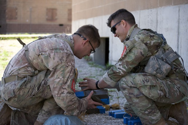 1LT Jeremy Y. Matsumoto and Capt. Erwin J. Marciniak from 299th Brigade Engineer Battalion, 1st Stryker Brigade Combat Team, 4th Infantry Division carefully preps a charge for a demolition exercise du