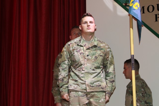 Spc. Jesse R. Wolfe stands at attention as he is recognized for his award.