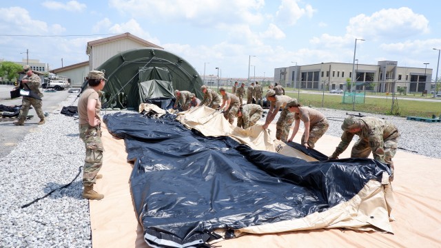 Soldiers lay out the new air-supported TEMPER tent on the ground