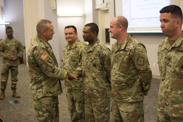 CSM Rodger W. Mansker, AMC, presents coins of excellence at the 2019 HQDA G-4 Sustainment Senior Enlisted Leader Development Symposium.