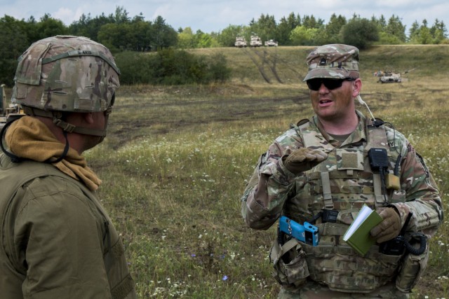 Sfc. Timothy Paddock, an Observer Controller Trainer (OCT) assigned to the Joint Multinational Readiness Center (JMRC) conducts an After Action Review (AAR) with the 1st Brigade 1st Infantry Division