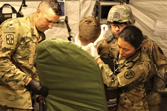 AMCT3 Soldiers examine a casualty during field training exercise 