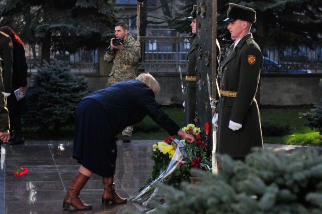A woman honors fallen soldiers of the Ukrainian Armed Forces (UAF) by placing flowers at the base of a monument during a commemoration ceremony hosted by the UAF in Kyiv, Ukraine, 14 Feb. 2020. Soldiers from Task Force – Juvigny joined Ukrainian...