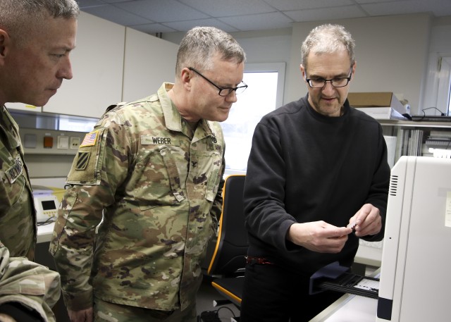 Col. Michael Weber and Command Sgt. Maj. Thurman Reynolds, Landstuhl Regional Medical Center command team, speak with Dr. Michael Koenig, technical supervisor, Virology Laboratory, to learn about LRMC’s Centers for Disease Control and Prevention...