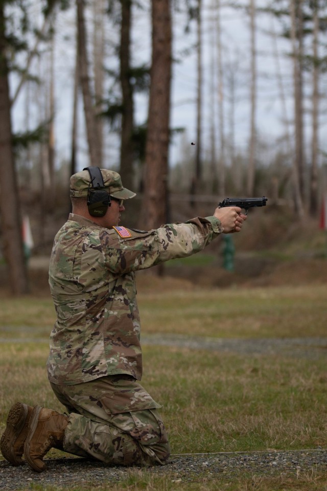 Sgt. 1st Class Daniel Boring with G-34 Protection, Headquarters Support Company, Headquarters and Headquarters Battalion, I Corps, executes the kneeling portion of the M9 pistol qualification at Joint Base Lewis-McChord, Washington, March 3, 2020. The new weapons qualification has grouped all hand-held weapons into a single training circular, TC 3-20.40.(U.S. Army photo by Pfc. Laurie Ellen Schubert)