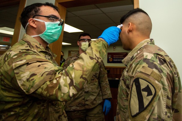 Soldiers stationed at Camp Casey conduct pre-screening processes on individuals awaiting entry to the base in South Korea, Feb. 26, 2020.  The Army has rolled out new allowances for Soldiers and families facing official travel delays or in quarantine amid the COVID-19 virus outbreak. 