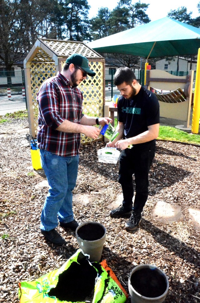 Joseph Jaurghi and Alexander Goburn, Miesau Army Depot Child Development Center employees, clean up a garden the CDC children planted before the facility was shut down for COVID-19 precautions.