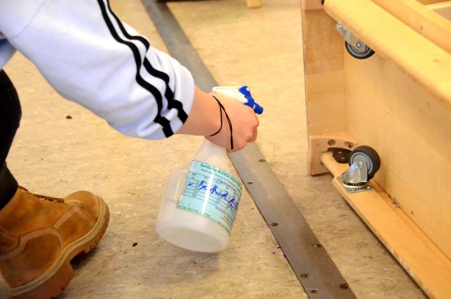 A Miesau Army Depot Child Development Center staff member sanitizes the underside of a rolling book case during a deep cleaning while all CDCs in the USAG Rheinland-Pfalz are closed as a precaution against COVID-19.