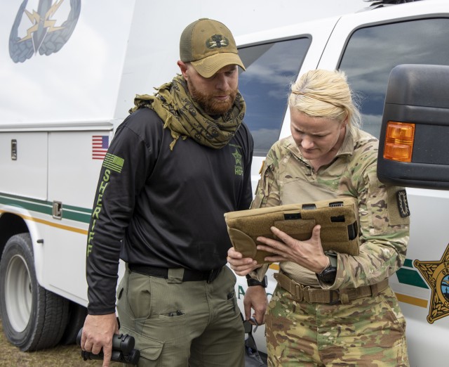 Staff Sgt. Heather Cockrell, 744th Ordnance Company (EOD), and Christopher Heavey, Orange County Count Sheriff’s Office, examine an X-ray of an explosive device left on a commuter bus during Raven’s Challenge on March 4, 2020. Raven’s...