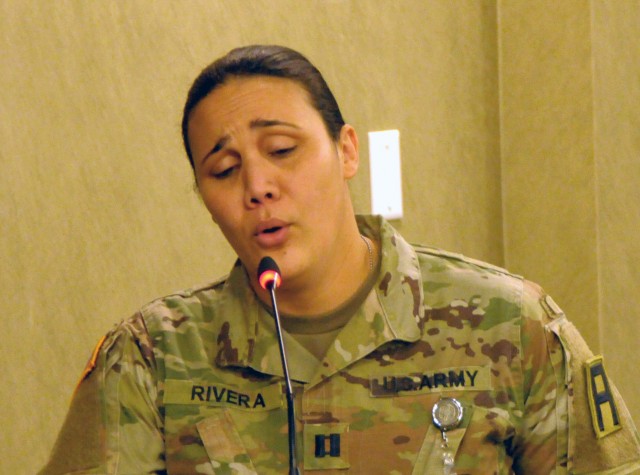 Capt. Karmi Rivera, a First Army plans and operations officer, performs a musical number in the Pershing Conference Room of First Army headquarters on Rock Island Arsenal, Ill.