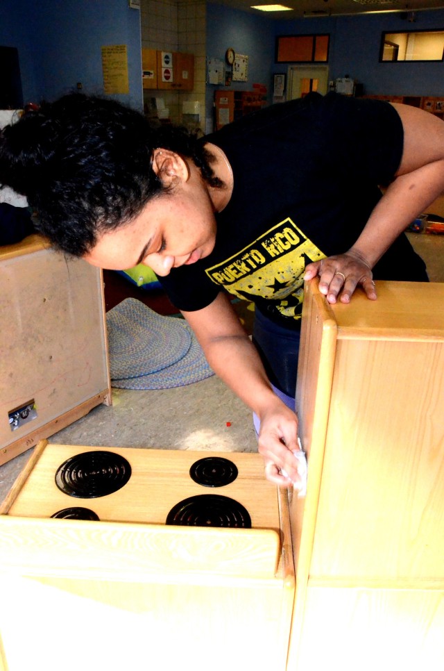 Claudine Jean, Miesau Army Depot Child Development Center employee, deep cleans a toy kitchen while the facility is closed for COVID-19 precautions.