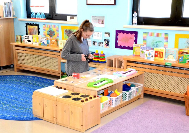 Nicole Radek, Miesau Army Depot Child Development Center staff member, replaces decorations that were scraped off of furniture in a CDC classroom during deep cleaning as a precaution against COVID-19.