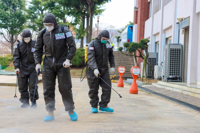 Two U.S. Army Soldiers and a Republic of Korea Army Soldier spray a COVID-19 infected area with a solution of disinfectant in Daegu, Republic of Korea, March 13, 2020. The Soldiers wear personal protective equipment with the primary function of...