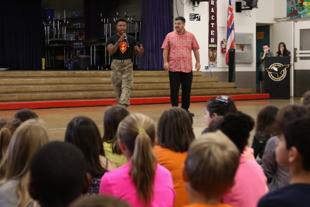 Sgt. Chaquan Jones, member of the 25th Infantry Division Hui Ha'a team, speaks with students at Major General William R. Shafter Elementary School about the Hui Ha'a team prior to a traditional dance performance at Fort Shafter, Hawaii on March 3, 2020. The team performed as part of the schools' May Day kick off celebration. (U.S. Army photo by Staff Sgt. Alan Brutus)
