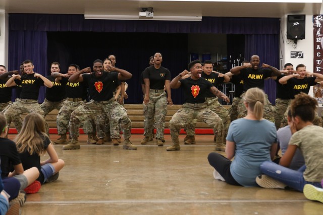 Soldiers assigned to the 25th Infantry Division who are part of the Hui Ha'a Team perform a traditional Hawaiian warrior dance for students at Major General William R. Shafter Elementary School at Fort Shafter, Hawaii on March 3, 2020. The team performed as part of the schools' May Day kick off celebration. (U.S. Army photo by Staff Sgt. Alan Brutus)