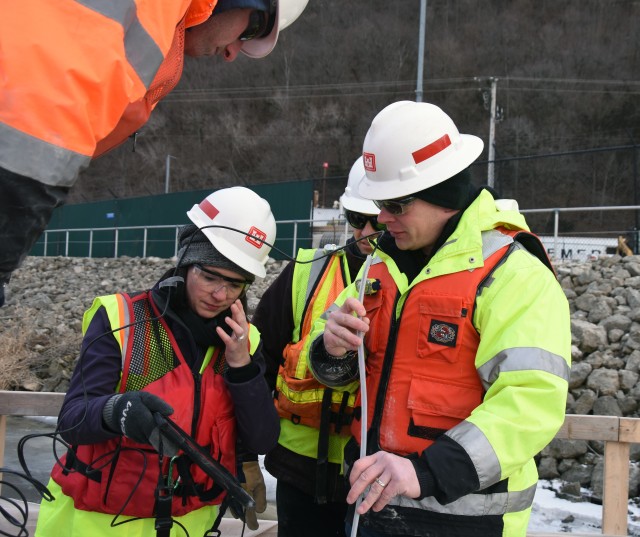 (Left to right) Project manager Kim Warshaw and engineers Jake Fall and Wade
Carr, use a remote camera to inspect a void in the upstream guidewall at Lock
and Dam 8 near Genoa, Wisconsin, Jan. 8.