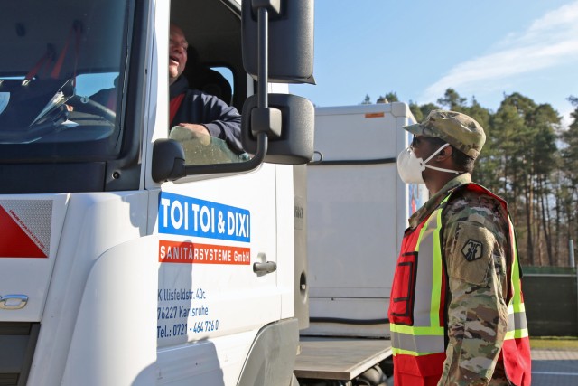 U.S. Army Reserve Sgt. Andre Lewis, a chemical, biological, radiological, nuclear noncommissioned officer with the 7th Mission Support Command, asks COVID-19-related screening questions to a truck driver before he can enter the gate of U.S. Army post Daenner Kaserne in Kaiserslautern, Germany, March 19, 2020. Daenner Kaserne is home to the 7th MSC headquarters, the only U.S. Army Reserve command stationed in Europe.