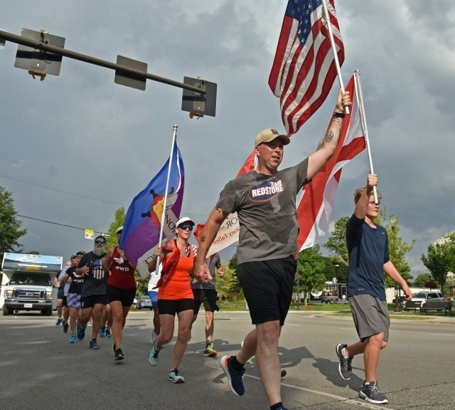 Carrying the American flag, Command Sgt. Maj. Billy Counts participates in the Madison County leg of America’s Run for the Fallen in 2018. Each mile of the nationwide route was dedicated to individual service members and their families.