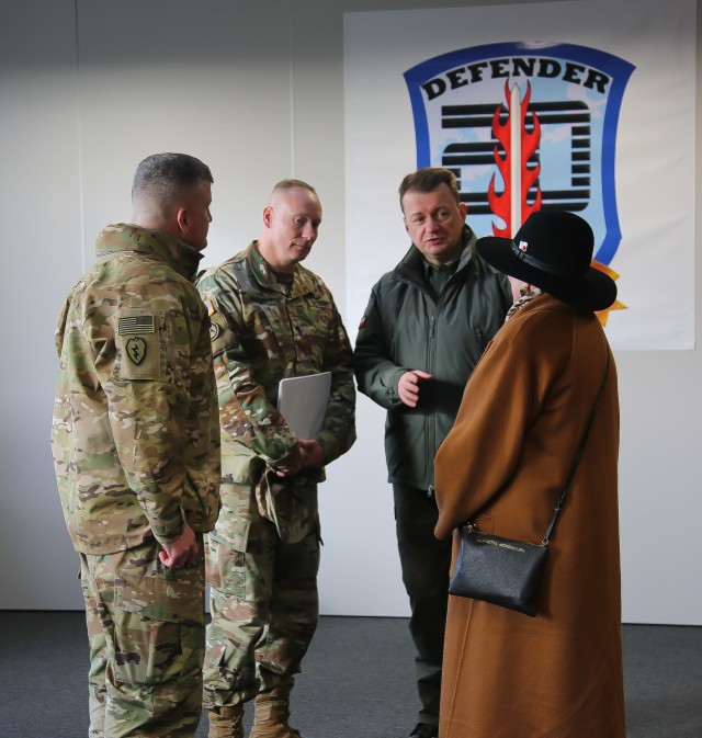 Col. Timothy O'Connor (left), 1st Infantry Division Forward Commander, speaks with U.S. and Polish officials during a troop engagement event at the Ziemsko Airfield, Poland, on March 11, 2020.