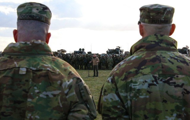 Col. Timothy O'Connor, 1st Infantry Division Forward Commander (left), and Lt. Col. Jayson Putnam, 9th Brigade Engineer Battalion, 2nd Infantry Brigade Combat Team Commander, listen to the remarks given by Andrzej Duda (center), the President of...