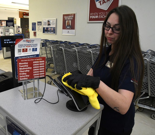 An employee at the Fort Drum Exchange wipes down her work area. This has become a constant safety measure taken to clean and sterilize surfaces that customers and associates frequently touch. The Coronavirus (COVID-19) pandemic has created...