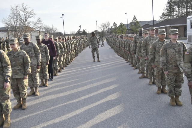 Golf Company, 244th Quartermaster Battalion drill sergeants look over troops moments before proceeding to classrooms March 20 on B Avenue near the Soldier Support Center.  The advanced individual training Soldiers were marched to learning facilities in columns of two, distanced roughly 10 feet apart while each Soldier was separated by more than an arm's length in each column. Soldiers are normally marched in columns of four, but that practice was changed due to new social distancing policies implemented two weeks ago as a preventative measure to combat the coronavirus spread.
