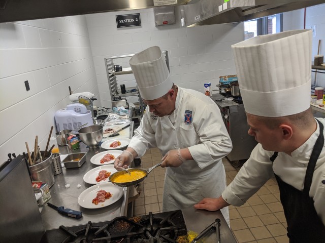 Sgt. Joshua Hoyt, team captain, and his apprentice Pfc. Jonathan Arendale work on the Armed Forces Chef of the Year menu during a rehearsal at the Fort Drum Culinary Arts Center in February. The team recently returned from the 45th Joint Culinary...